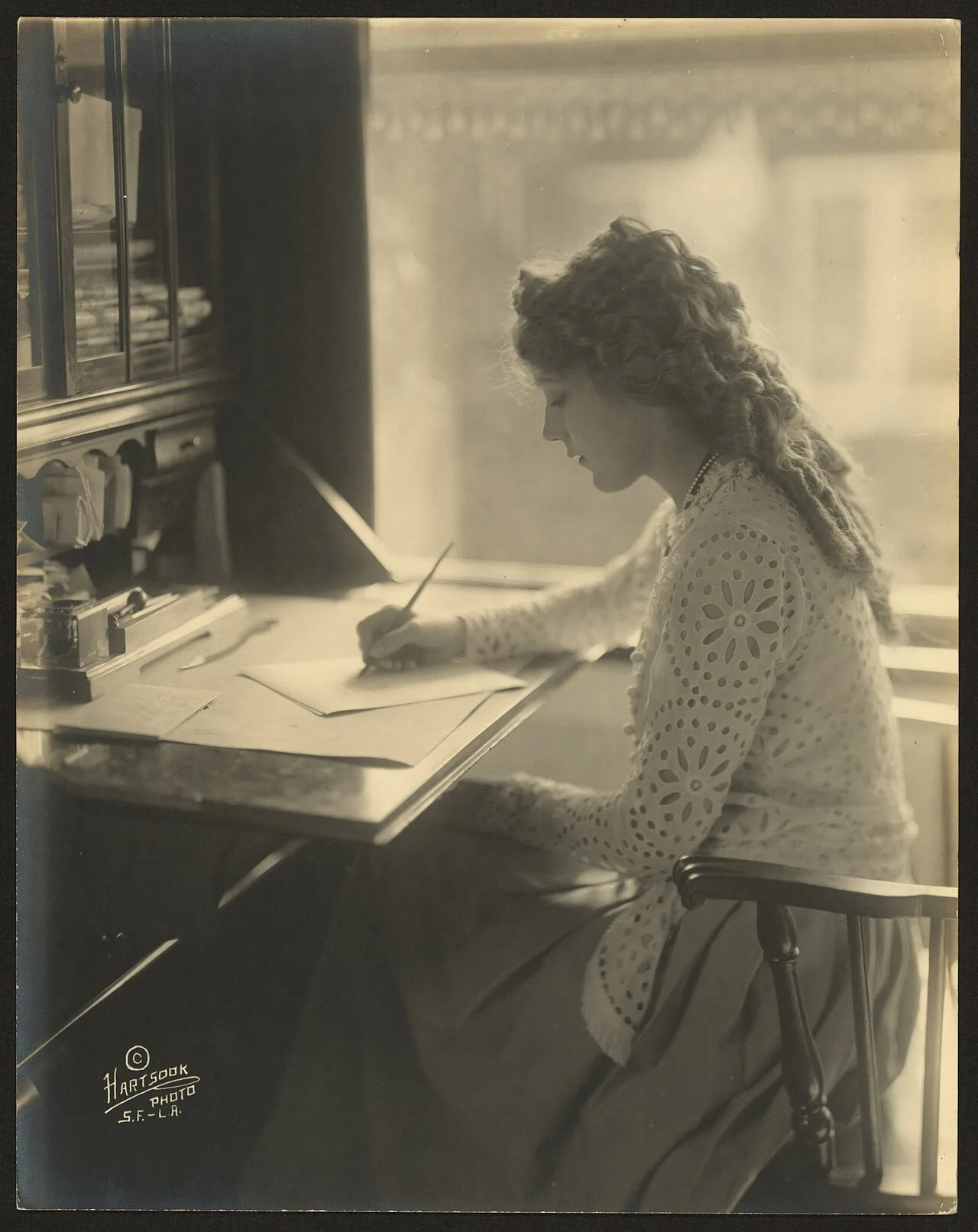 Mary Pickford writing at a desk in 1918