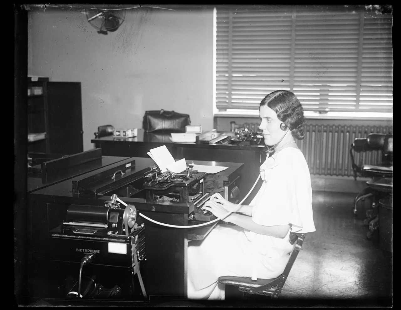 A woman working at a typewriter in an office in 1932